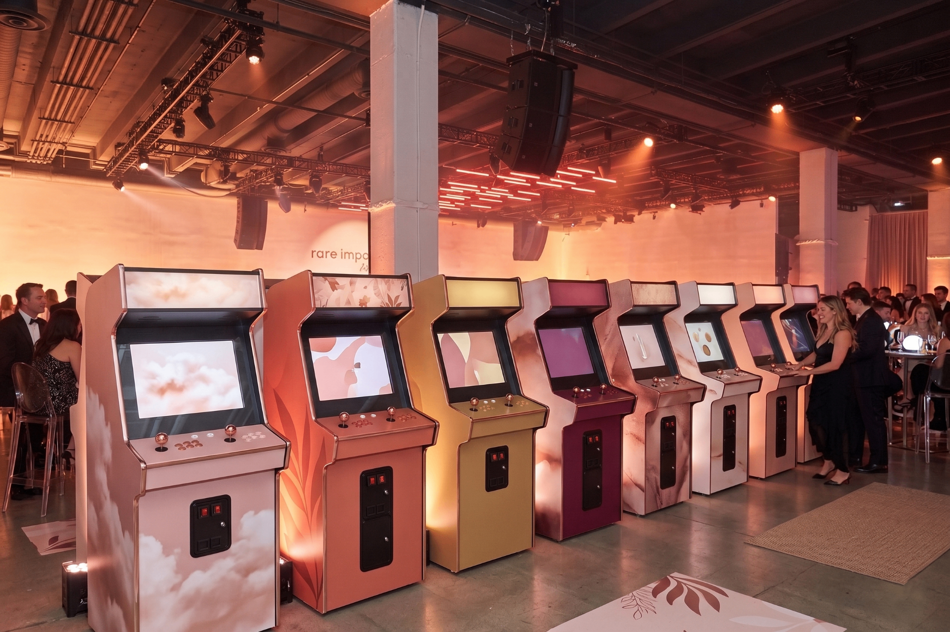 Row of five custom arcade cabinets in coral, blush, ochre and rose colorways